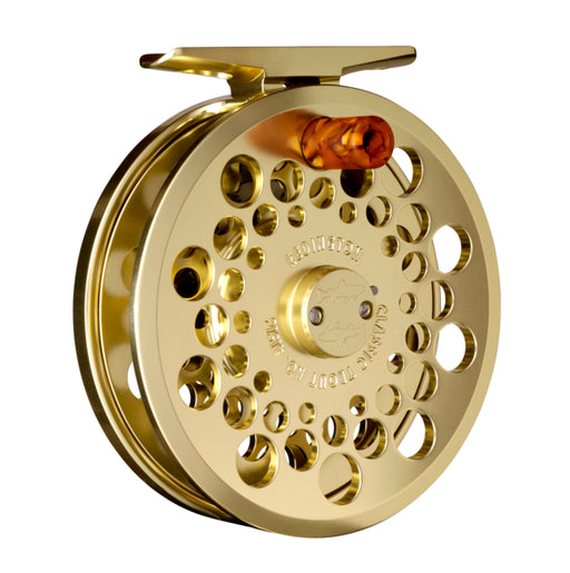 Gold fly fishing reel on a white background