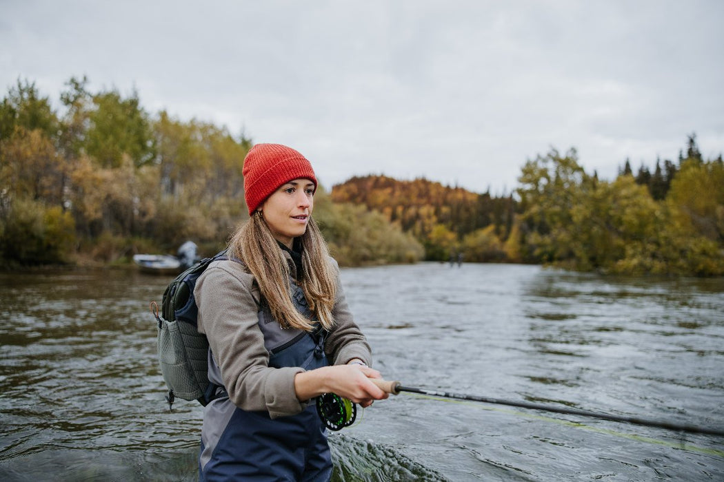 An angler with the Fishpond stormshadow sling pack on her back while fishing