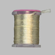 UTC Antron yarn spool in light gold with loose thread end above the bobbin