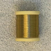 Four-strand floss spool with golden yellow thread on a cream core