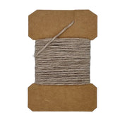 Wool yarn spool with gray yarn wrapped on brown cardboard core, loose strand on top.