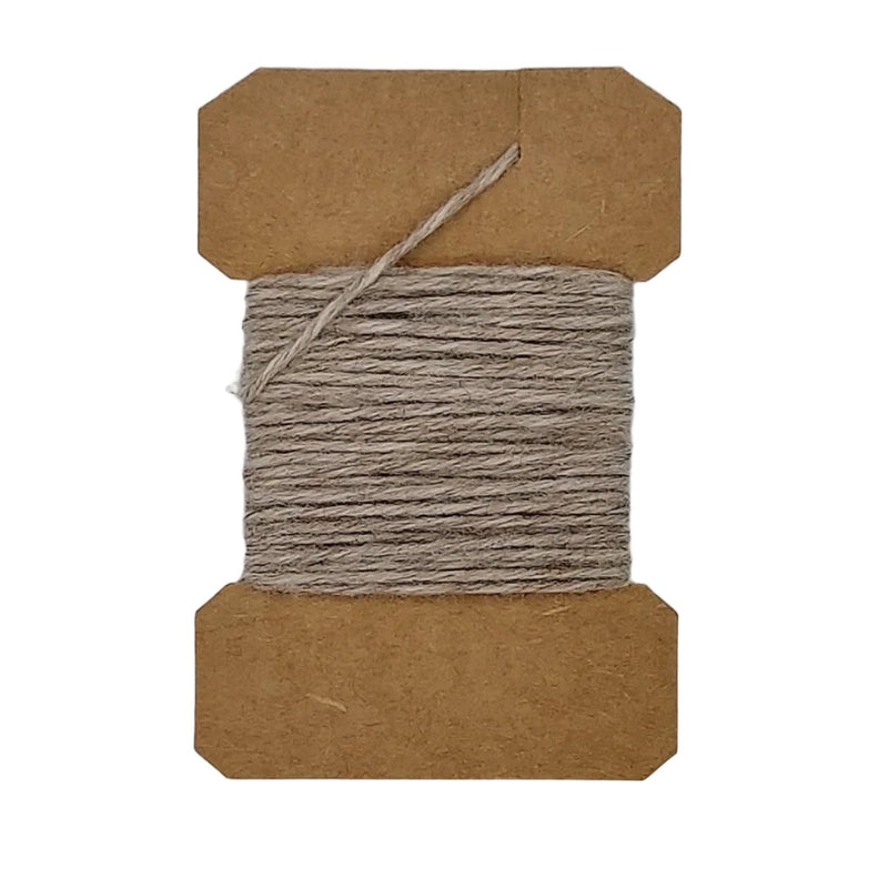 Wool yarn spool with gray yarn wrapped on brown cardboard core, loose strand on top.