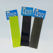 Thin Skin transparent material sample packs with green, black, and dark gray strips