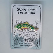 Brook trout enamel pin with green fish design on a backing card.