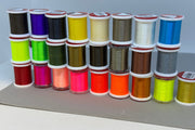 70 denier thread spools, assorted colors, stacked for display
