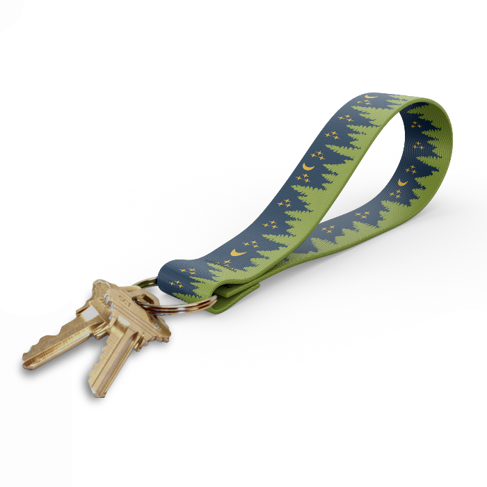 key fob with a design on the strap of trees and a night sky