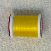 Spool of 70 denier thread in yellow with red side flanges