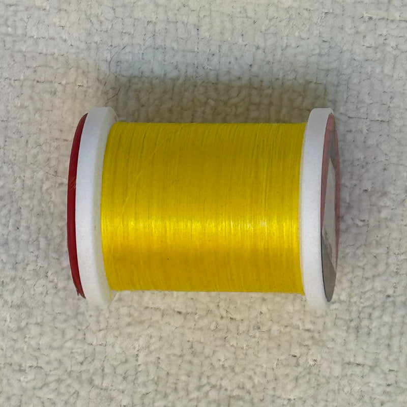 Spool of 70 denier thread in yellow with red side flanges