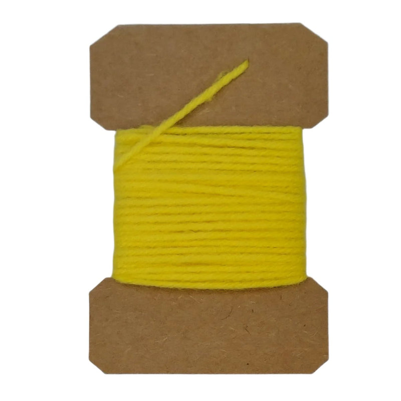 Wool yarn spool with yellow yarn wrapped on brown cardboard core.