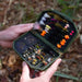 hands holding an open olive fly box filled with flies