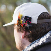 Fly caddy patch on a cap brim holding colorful fishing flies