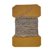 Wool yarn spool with gray yarn wrapped on brown cardboard core.