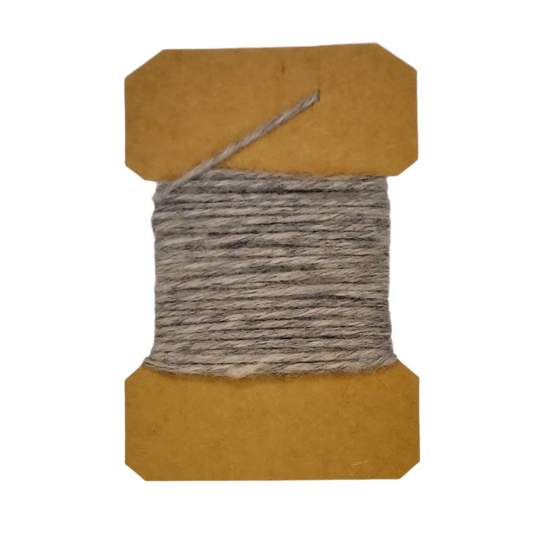 Wool yarn spool with gray yarn wrapped on brown cardboard core.