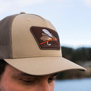 Pale khaki trucker cap with mesh side panels and embroidered logo patch
