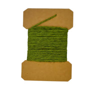 Wool yarn spool with olive green yarn wrapped on brown cardboard core.