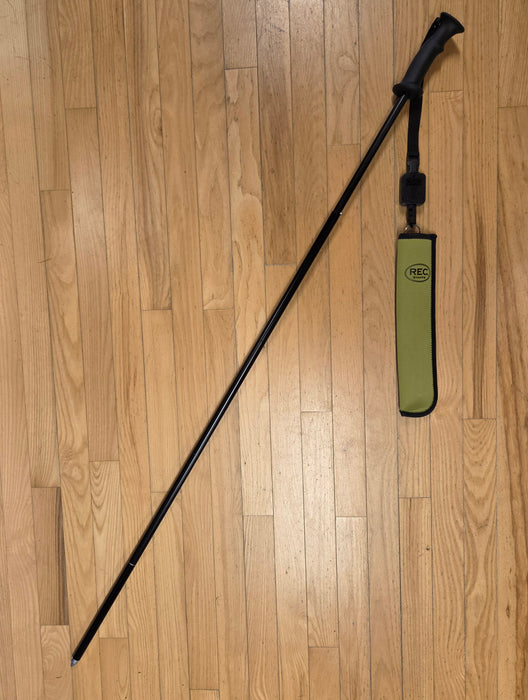 The REC black wading SureStaff extended lying on a light brown floor with its Sheath