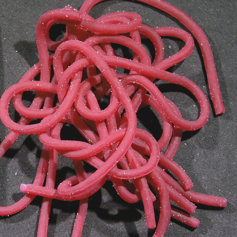 Single plastic worm toy, pink, tangled in a pile.
