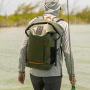 Roll-top backpack in olive green worn on person, front pocket, padded shoulder straps.