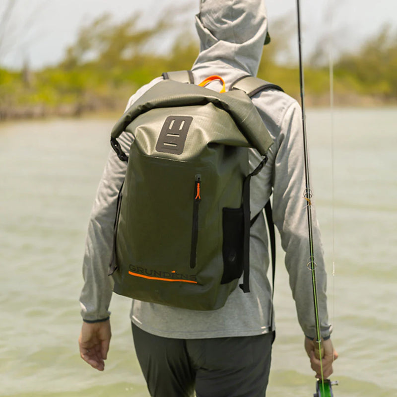 Roll-top backpack in olive green worn on person, front pocket, padded shoulder straps.