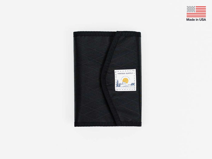 Foldable stash bag in dark gray with black trim and label patch