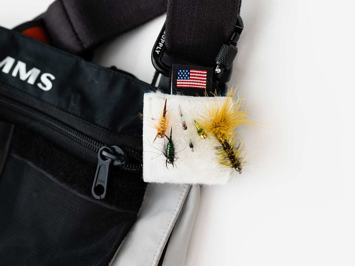 Fly patch with white backing and feathered fly lures with fuzzy yellow tails