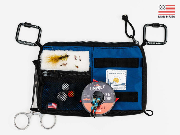 Utility pack with black front and blue zip panels, white fur patch and pouches