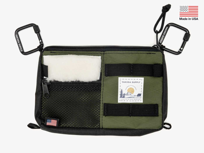 Utility pack with olive and black panels, white fur patch, zip pockets and label