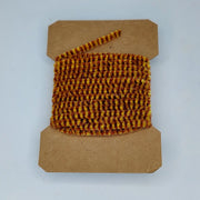 Medium variegated chenille yarn spool, rust brown and amber checkered texture