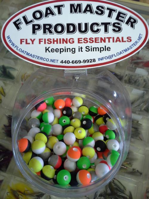 container of small round brightly colored styrofoam strike indicators used in fly fishing with nymph flies