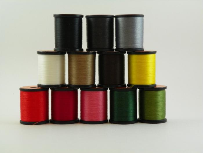 Assorted sewing thread spools with multiple colors and black caps