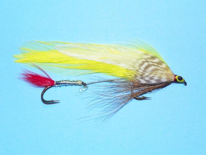 Tandem fishing fly with yellow and green feather tail, red accent, and black hook