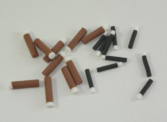 brown or black foam cylinders with white ends used for tying fly fishing flies to imitate ants