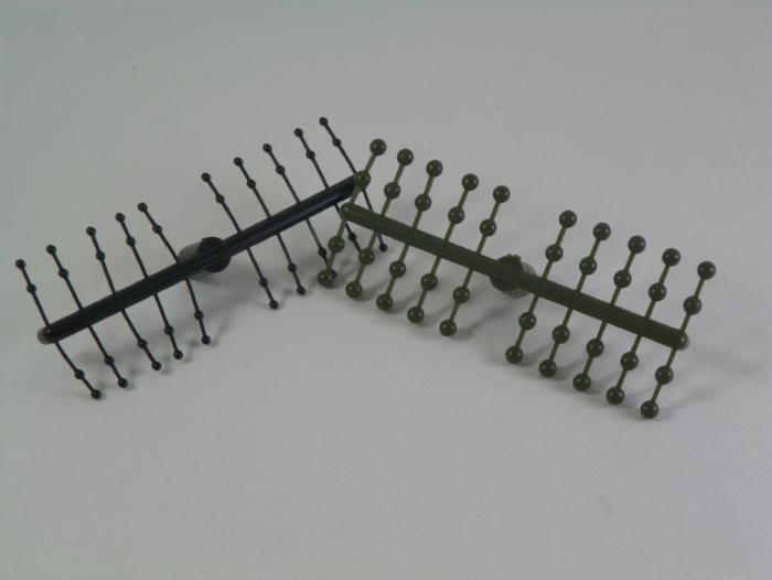 Mono Eyes hair accessory with two comb-like rows of metal pins, black and olive