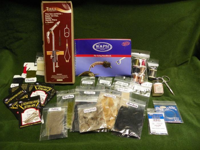 contents of a Wapsi beginners fly tying kit including vise, tools, hooks, thread, chenille, wire, feathers and more