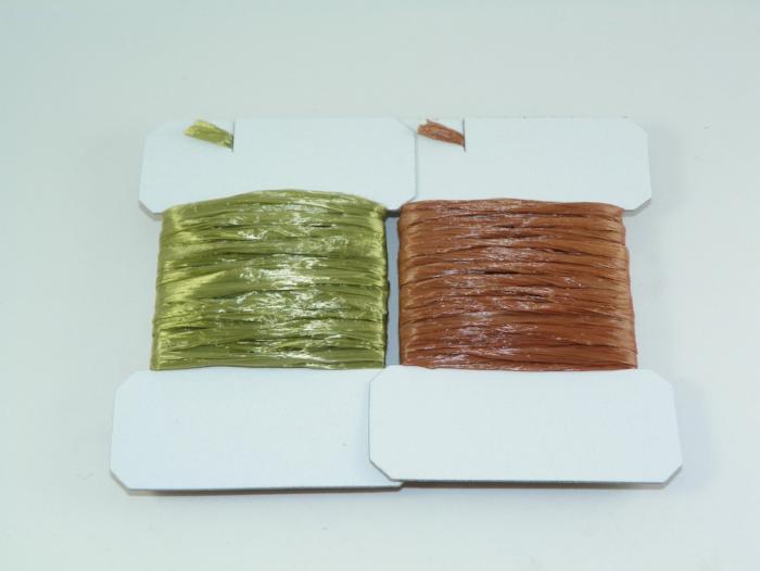Straw thread spools in olive and brown on white holders