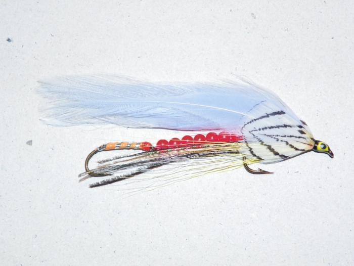 Beaded tandem fishing fly with silver body, red bead chain, and blue-white feather tail