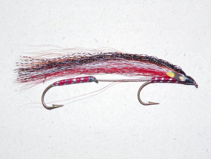 Tandem fishing lure with red and black body, feather tail, and two metal hooks