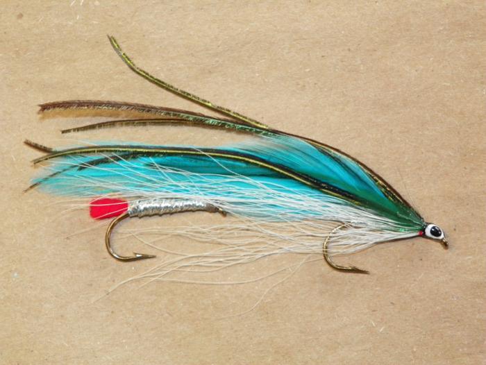 Fishing lure with teal blue feather tail and red accent, single hook