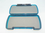 Blue fly box open with clear plastic compartment lid and gray foam insert