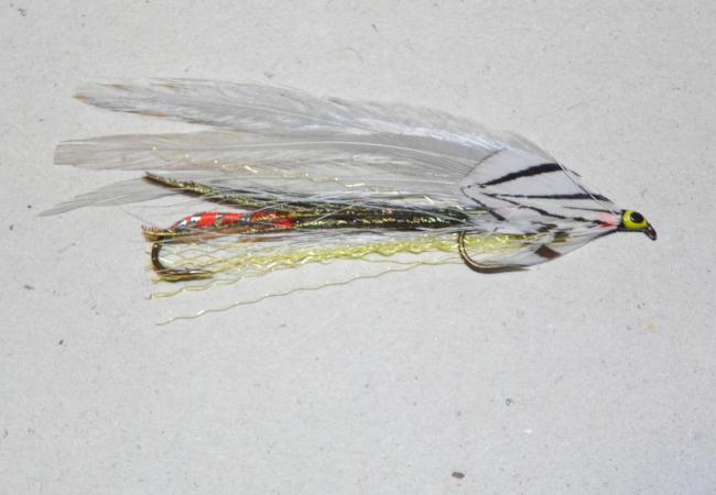 Tandem fishing lure with green head, gray-and-white wings, and gold hooks