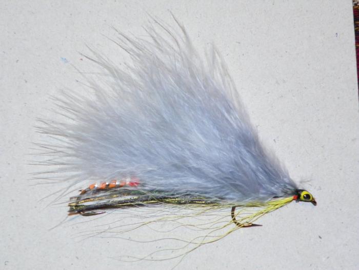 Marabou fishing fly lure with blue-gray feather tail, green thread body and orange accents.