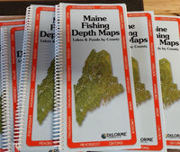 a pile of spiral bound Maine Fishing Depth Maps books by DeLorme