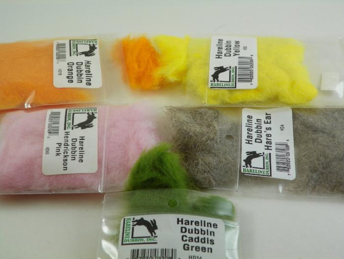 Fly tying dubbing packs in light yellow, orange, pink, green, and gray fibers