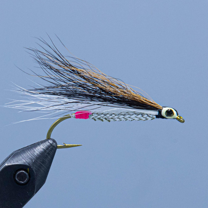 Fishing fly lure with black-and-tan feather tail and pink head accent