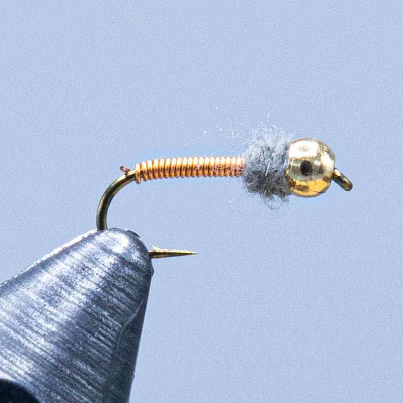 Beadhead fishing lure with gold bead, dark bristle body, and curved hook