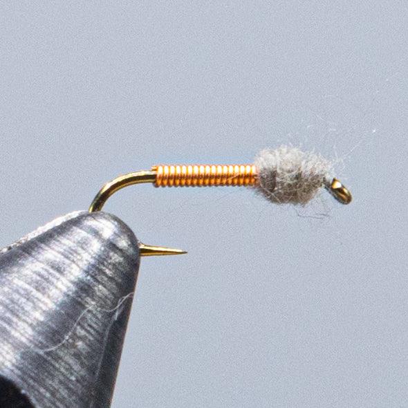 Fishing lure fly with gray dubbing and golden hook and wire body