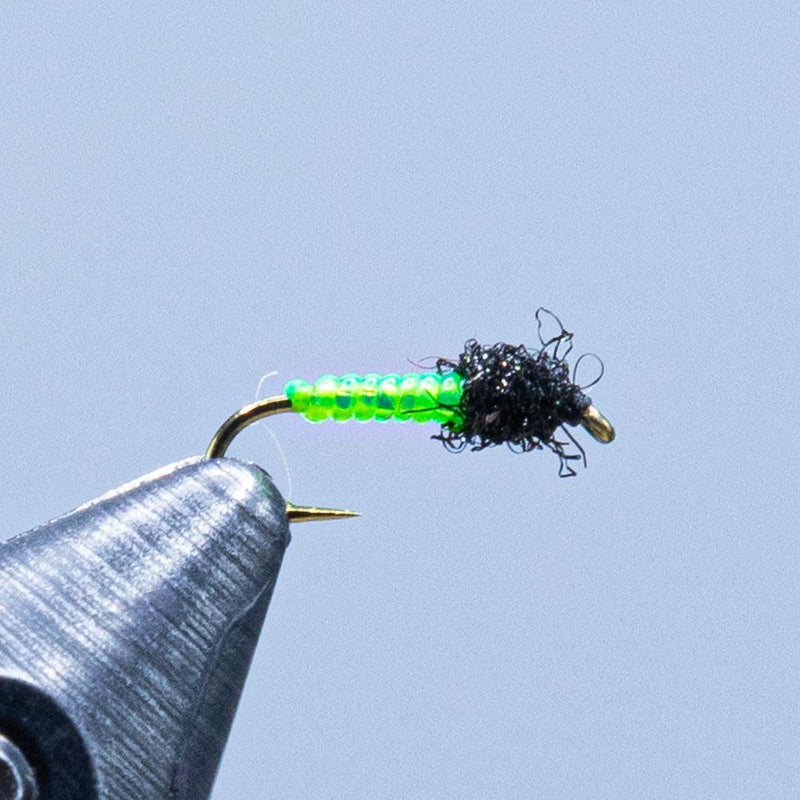 Green and black fishing lure worm on hook