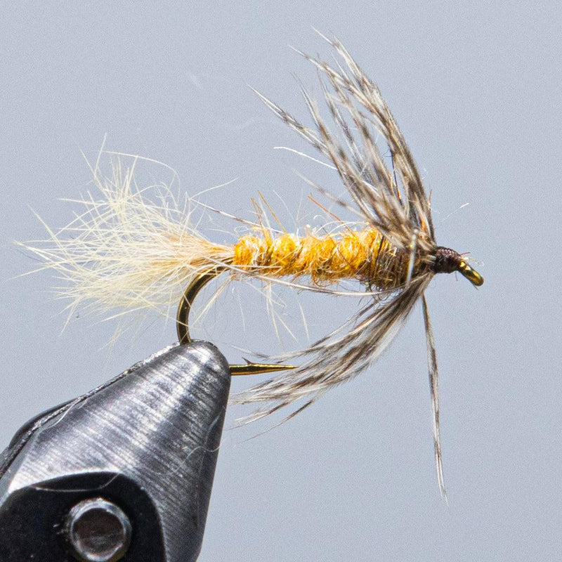 Fishing fly lure with gold body, brown/gray fur tail and small hook