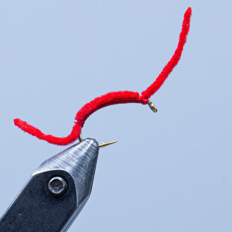 Red fuzzy fishing worm lure with hook