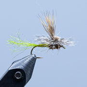 Caddis-style fly with light brown fibers and green accents on curved hook